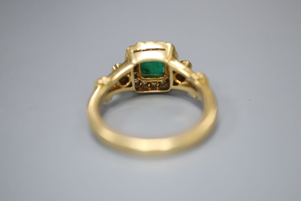 A modern 18ct gold, emerald and diamond cluster ring, size N, gross 6.6 grams.